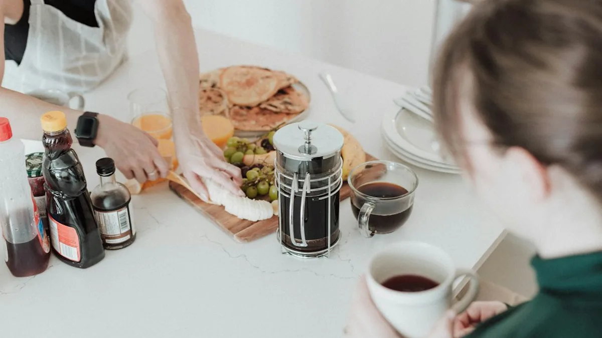Un petit-déjeuner en famille dans une cuisine claire : café, fruits et crêpes sur le plan de travail
