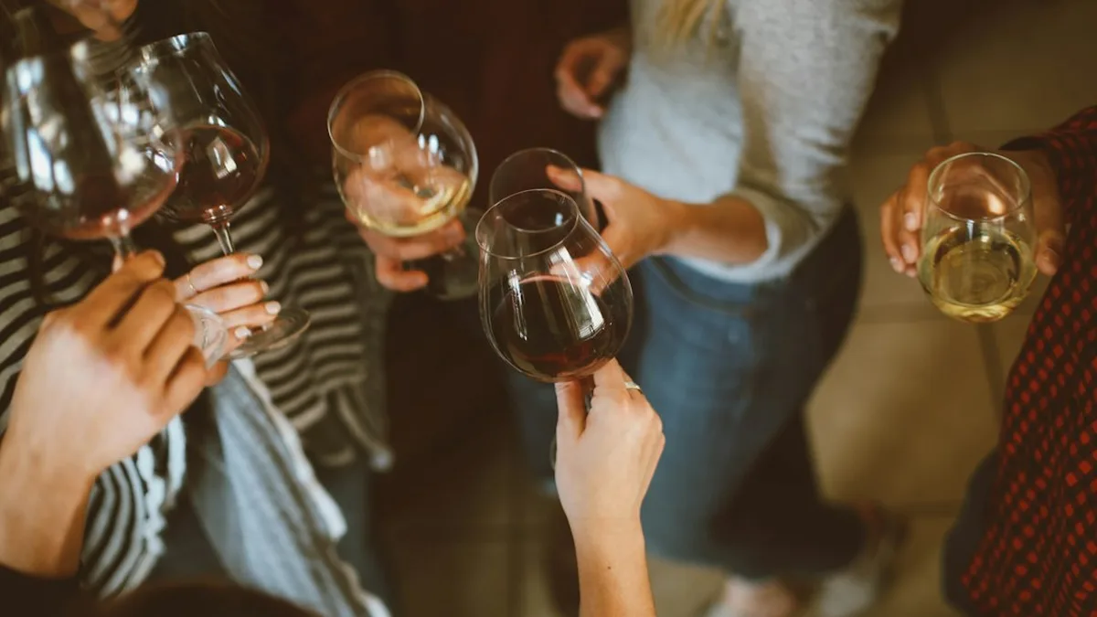Des amis trinquent avec des verres de vin rouge et blanc lors d'une soirée